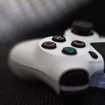 Egy Playstation 4 játékkonzol fehér kontrollerének közelképe.